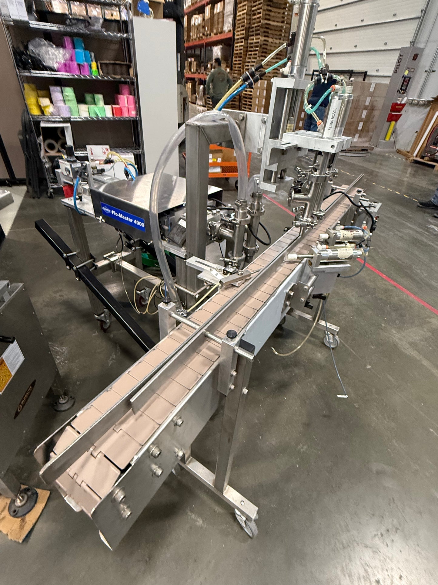 Geyer - Flo Master 4,000 - Dual Nozzle, Piston Filler with Diving Nozzles and Conveyor System.