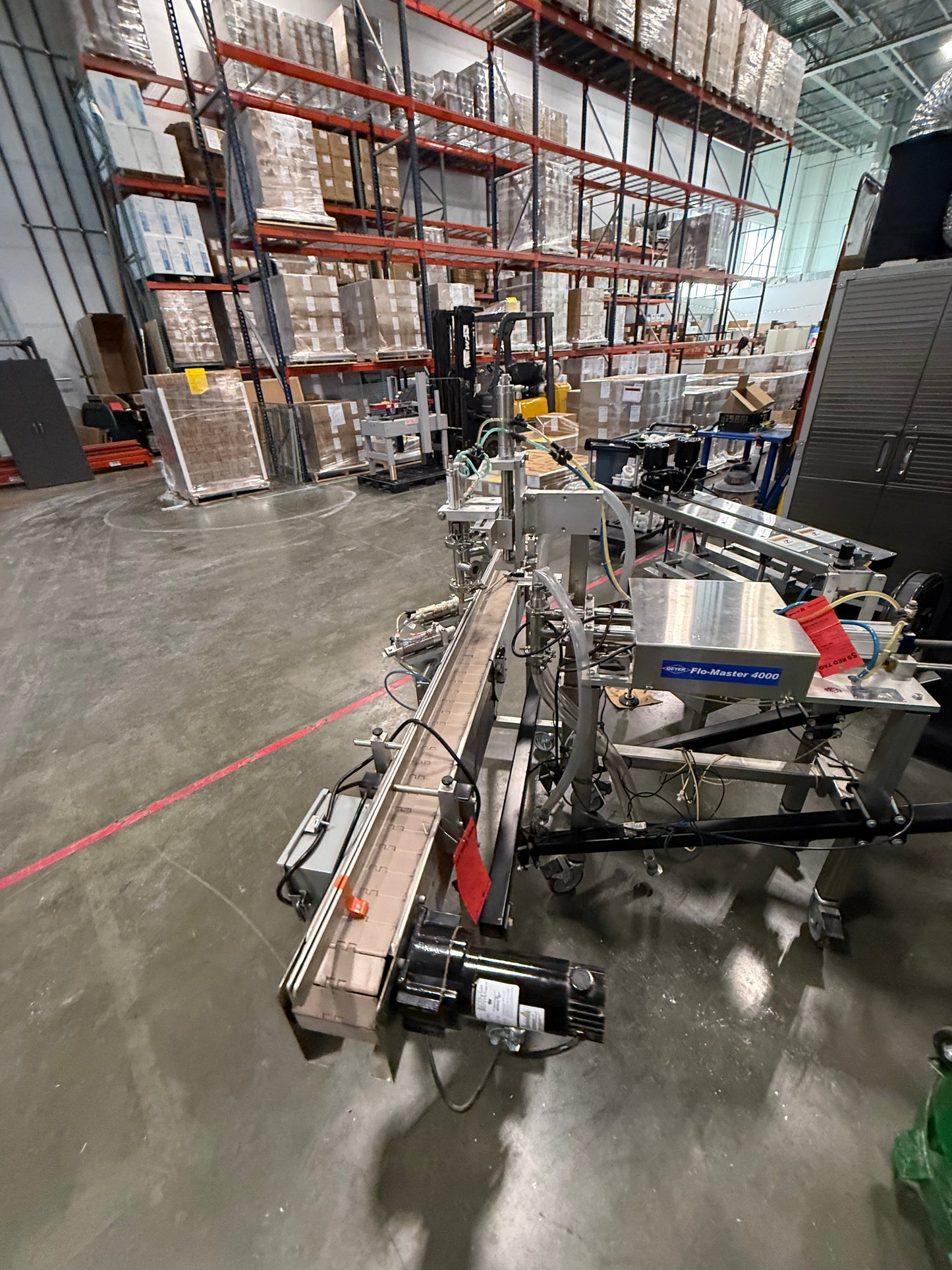 Geyer - Flo Master 4,000 - Dual Nozzle, Piston Filler with Diving Nozzles and Conveyor System.